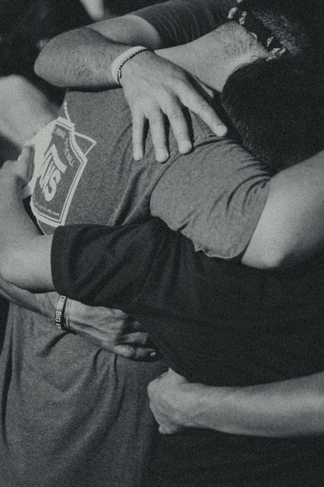 grayscale photography of men doing group hug