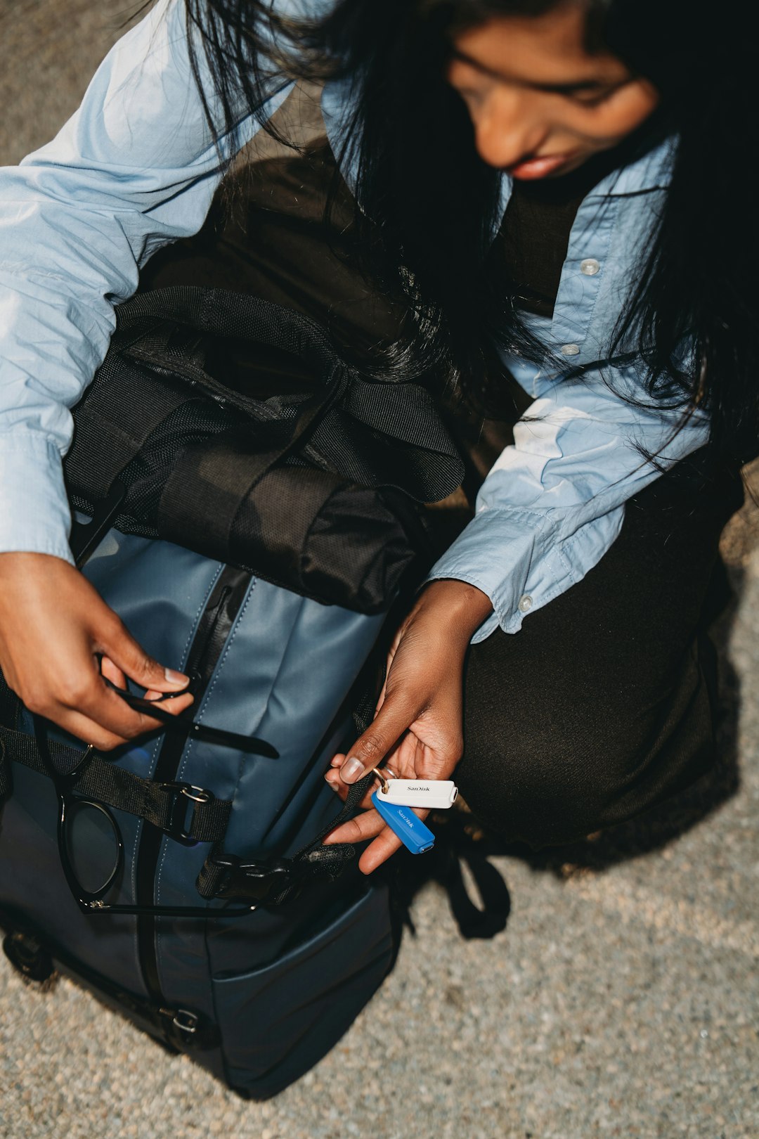 Person opening a backpack and holding keys.